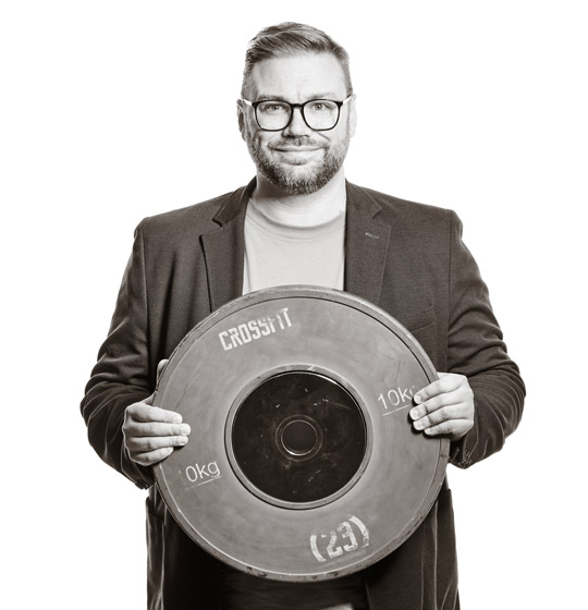 Michael hält eine Gewichtscheibe von 10 Kilo in den Händen