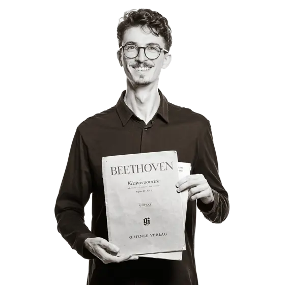 Maximilian hält Notenblätter mit der Aufschrift "Beethoven Klaviersonate" in den Händen.