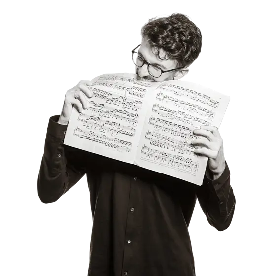Maximilian hält Notenblätter mit der Aufschrift "Beethoven Klaviersonate" in den Händen.