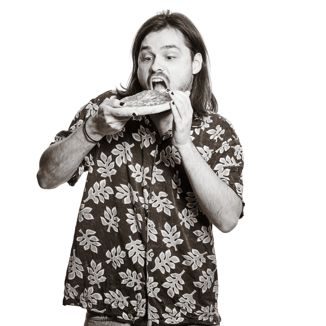 Portrait von Nicolas. Er hält breit lächelnd eine kleine Pizza in die Höhe. 
