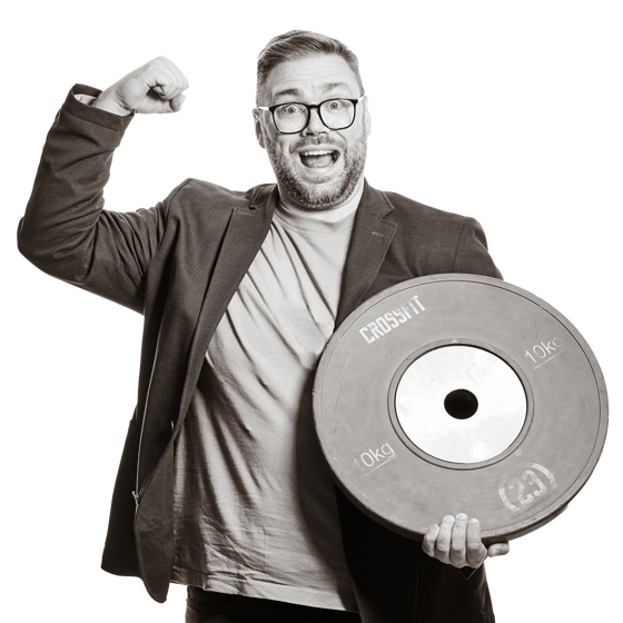Michael hält eine Gewichtsscheibe. Auf der Scheibe steht "10 kg" und "Crossfit".