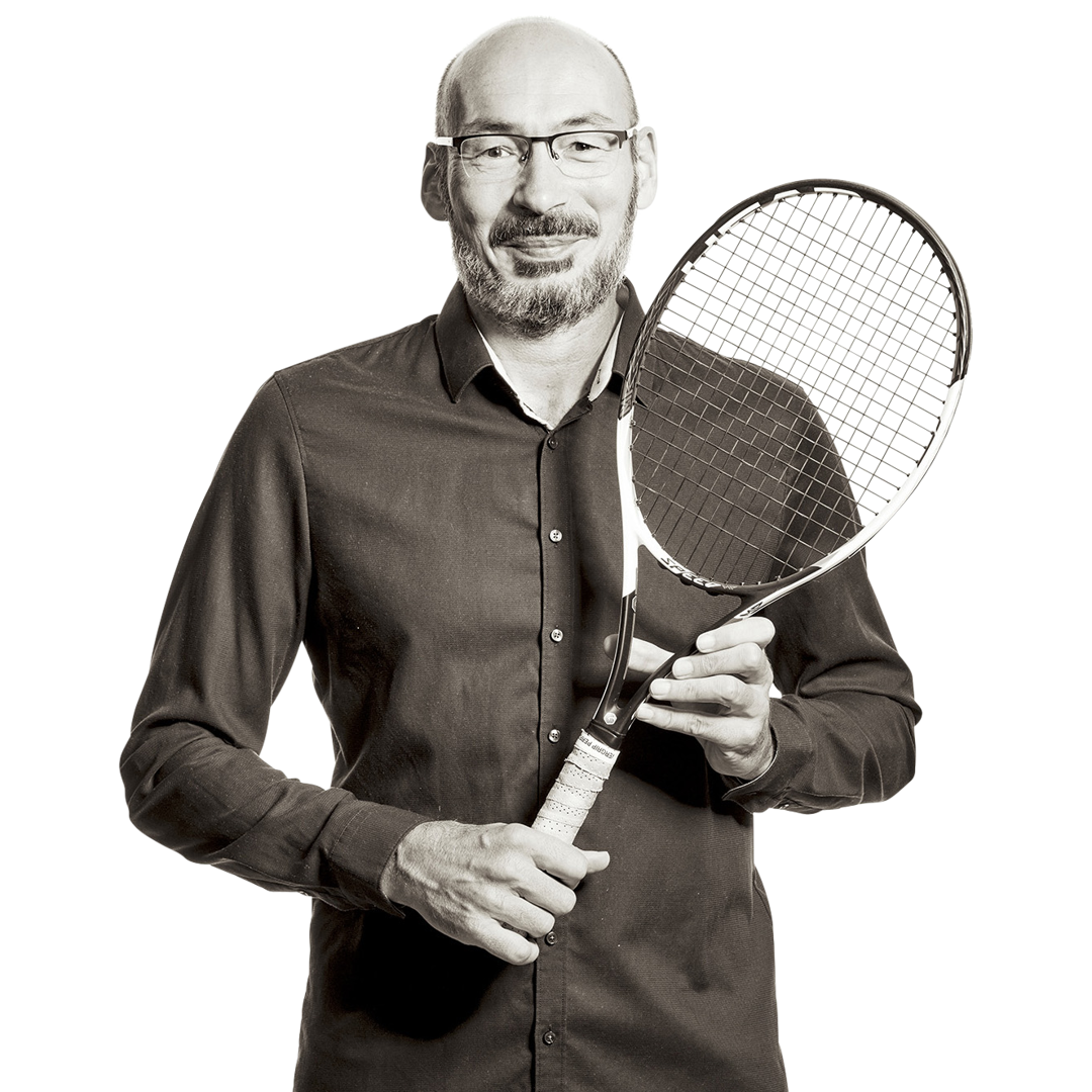 Michael hält einen Tennisschläger in den Händen.