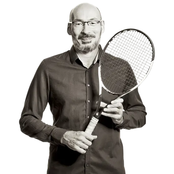 Michael hält einen Tennisschläger in den Händen.